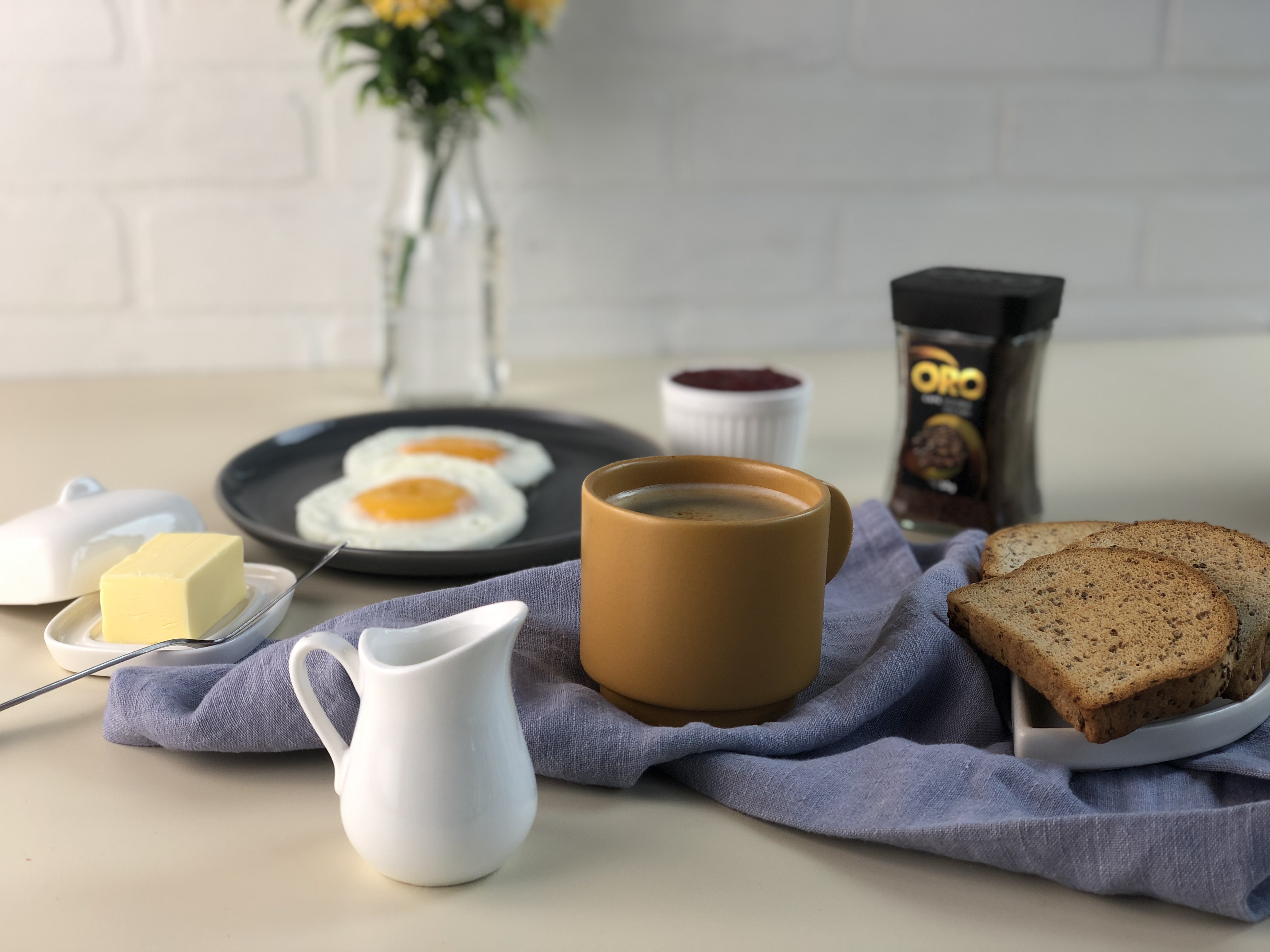 Escena de desayuno con café, huevos y tostadas